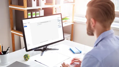 Man at computer with Assistant.IQ Man at computer working with AI tool for administration Assistent.IQ of the Bundesdruckerei