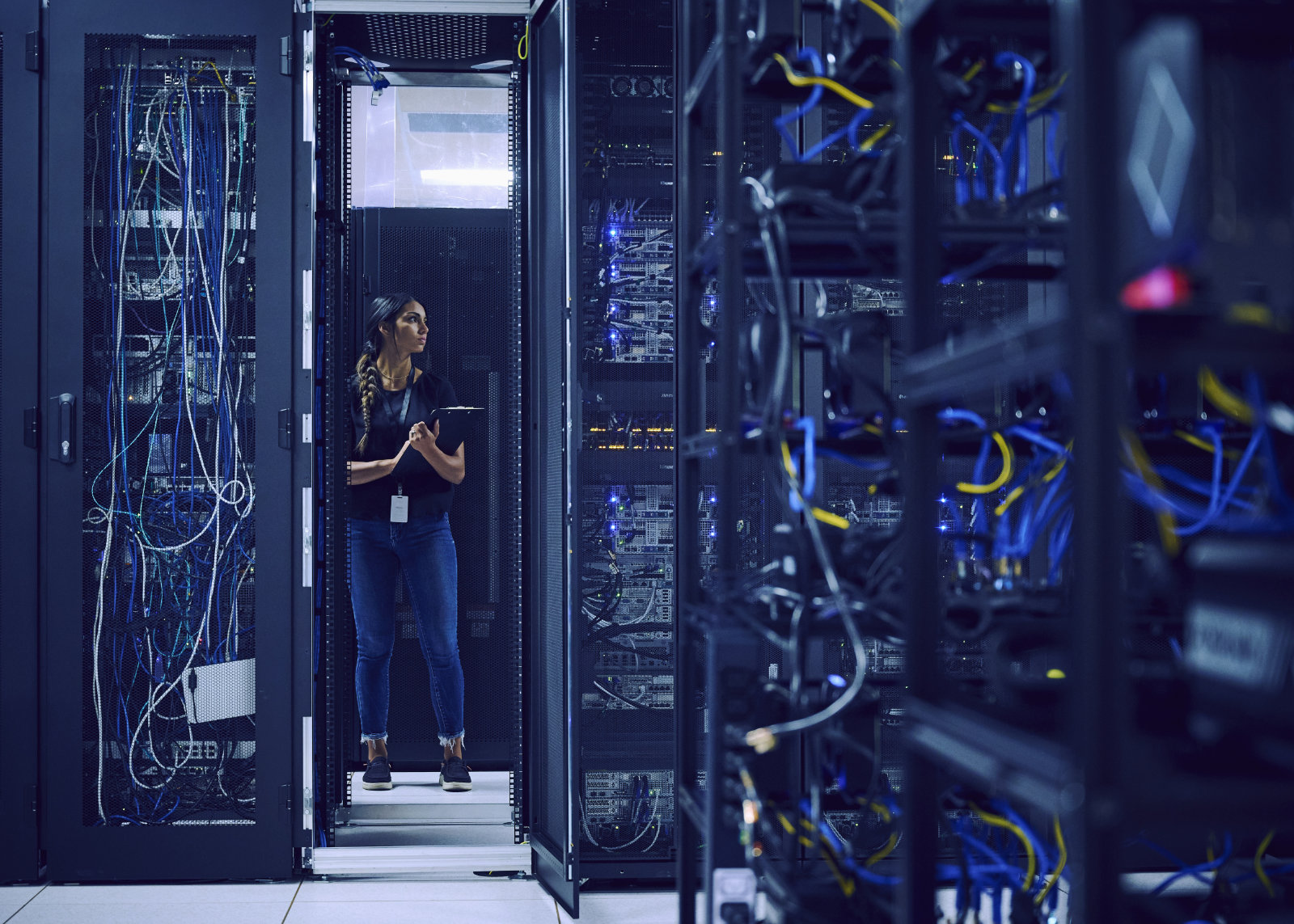 Frau mit Klemmbrett in Serverraum Frau mit Klemmbrett in Serverraum