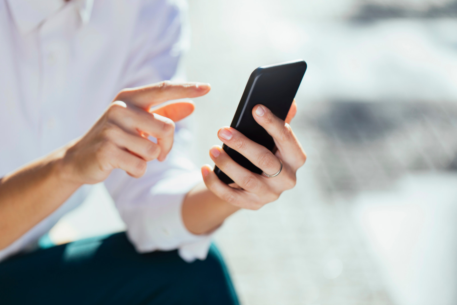 Eine Frau hält ihr Smartphone in den Händen