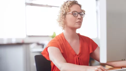 Frau sitzt am Computer.