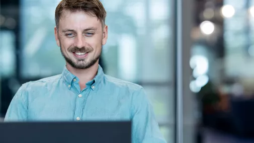 Ein Mann sitzt vor einem Computer im Büro